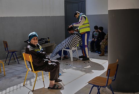 A displaced man who fled Israeli strikes in southern Lebanon receives a haircut in the playground of a school turned into a shelter in Beirut, Lebanon, Tuesday, March 10, 2026. 