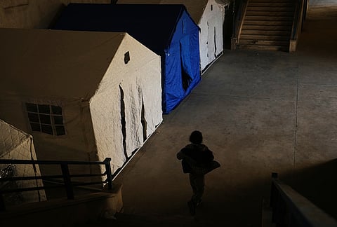 A displaced child plays past tents set up inside the Camille Chamoun Sports City Stadium, which has been turned into a shelter for people displaced by Israeli airstrikes in southern Lebanon and Dahiyeh, Beirut's southern suburbs, in Beirut, Lebanon, Tuesday, March 10, 2026. 