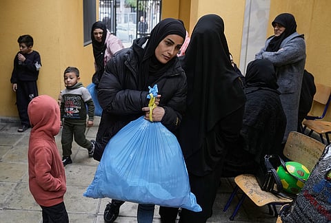 Displaced people fleeing Israeli airstrikes in southern Lebanon and Dahiyeh, Beirut's southern suburbs, arrive at a school turned into a shelter in Beirut, Lebanon, Saturday, March 7, 2026. 