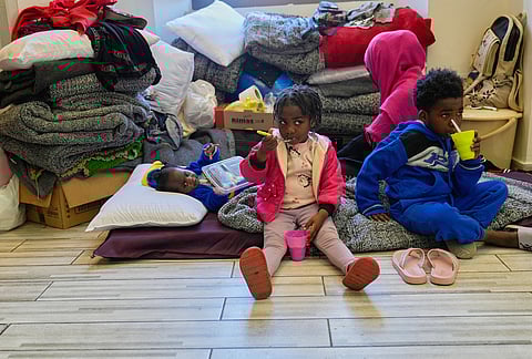 Displaced migrant children who among many others fled Israeli strikes in southern and eastern Lebanon and Beirut's southern suburbs take their food inside a room at Saint Joseph Church, which has been turned into a shelter for displaced migrants, mostly from African nations, in Beirut, Wednesday, March 11, 2026. 