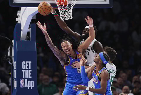 Boston Celtics center Neemias Queta, upper right, Oklahoma City Thunder forward Jaylin Williams, upper left, Thunder guard Shai Gilgeous-Alexander, front, and Celtics guard Hugo Gonzalez, back right, try for a rebound during the first half of an NBA basketball game in Oklahoma City.