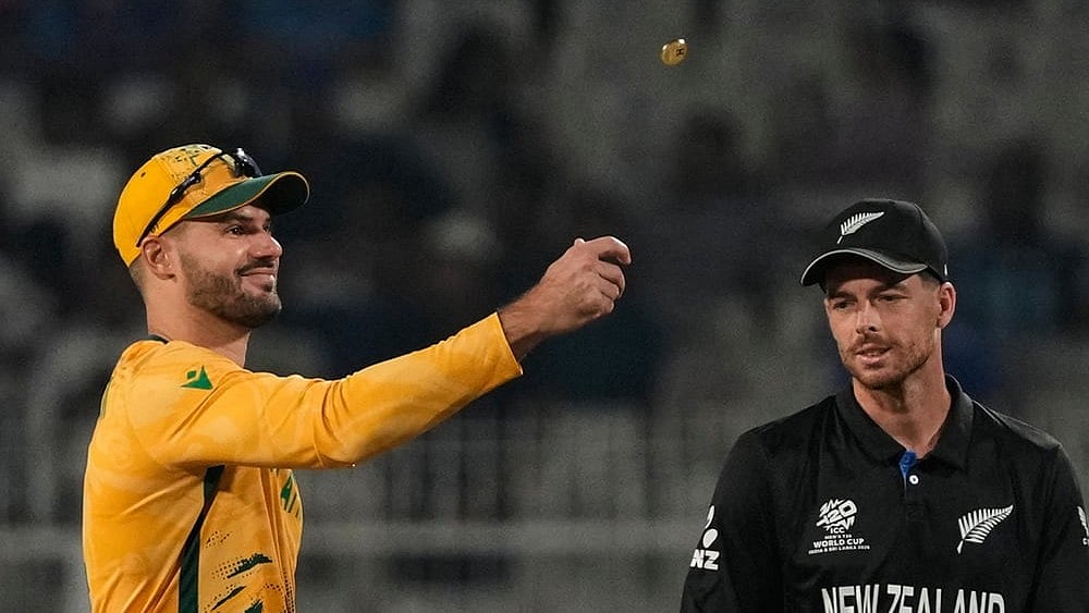 South Africa's captain Aiden Markram tosses the coin for toss as New Zealand's captain Mitchel Santner watches at the start of the first T20 World Cup cricket semifinal. - | Photo: AP/Anupam Nath