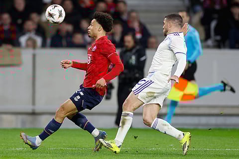 Lille's Tiago Santos, left, and Aston Villa's Emiliano Buendia fight for the ball during a first leg, round of 16 Europa League soccer match between Lille and Aston Villa in Lille, France.