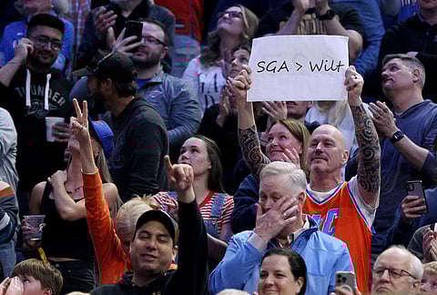 A fan holds a sign after Oklahoma City Thunder guard Shai Gilgeous-Alexander broke Wilt Chamberlain's 20-point streak record, during the second half of an NBA basketball game against the Boston Celtics, in Oklahoma City. 