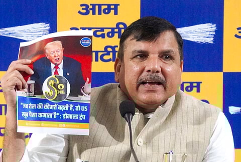 AAP MP Sanjay Singh shows a poster during a press conference, at party office in New Delhi. 