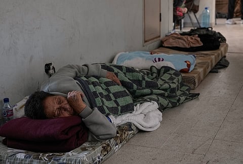 A displaced woman who fled Israeli airstrikes in southern Lebanon sleeps on the ground at the Bir Hassan Technical Institute, which has been turned into a shelter, in Beirut, Lebanon, Wednesday, March 11, 2026. 