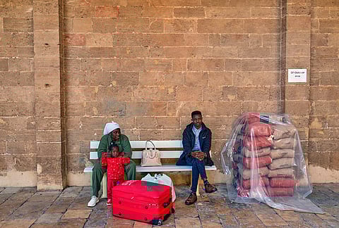 A displaced migrant family who among many others fled Israeli strikes in southern and eastern Lebanon and Beirut's southern suburbs wait to register at Saint Joseph Church, which has been turned into a shelter for displaced migrants, mostly from African nations, in Beirut, Wednesday, March 11, 2026. 