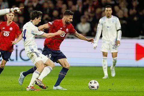 Aston Villa's Pau Torres, left, and Lille's Olivier Giroud fight for the ball during a first leg, round of 16 Europa League soccer match between Lille and Aston Villa in Lille, France.