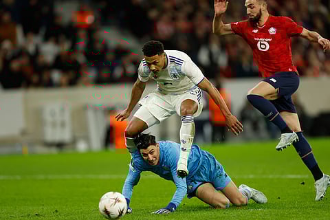 Aston Villa's Ollie Watkins falls over Lille's goalkeeper Berke Ozer during a first leg, round of 16 Europa League soccer match between Lille and Aston Villa in Lille, France.
