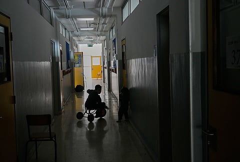 A displaced boy who fled Israeli strikes in southern Lebanon with his family plays on a bicycle in a classroom corridor at a school turned into a shelter in Beirut, Lebanon, Tuesday, March 10, 2026. 