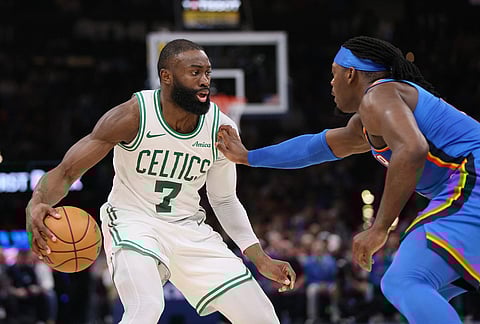 Boston Celtics guard Jaylen Brown (7) handles the ball against Oklahoma City Thunder guard Luguentz Dort, right, during the second half of an NBA basketball game in Oklahoma City.