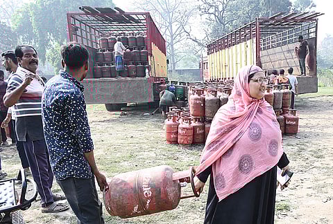 People carry an LPG cylinder at a gas agency, amid supply crisis in the country, in Patna, Bihar.