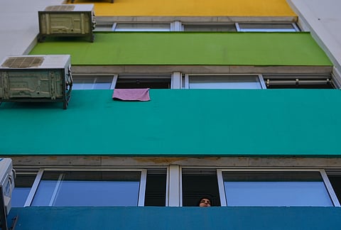 A displaced woman who fled Israeli strikes in southern Lebanon looks through a classroom window at a school turned into a shelter in Beirut, Lebanon, Tuesday, March 10, 2026. 