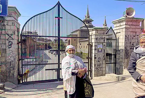 A woman outside a closed mosque on Jumat Ul Vida, in Srinagar.