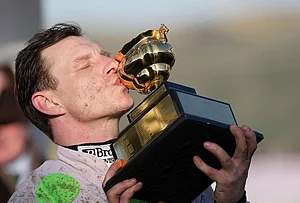 | Photo: AP/Dave Shopland : Paul Townend jockey of Gaelic Warrior the winner of the Gold Cup race, kisses the trophy after the presentation on day four of the 2026 Cheltenham Festival in Cheltenham, England