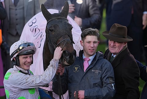 Paul Townend, left, jockey of Gaelic Warrior the winner of the Gold Cup race, celebrates with the trainer W P Mullins, right, in the winners enclosure on day four of the 2026 Cheltenham Festival in Cheltenham, England.