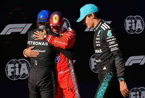 Mercedes driver Andrea Kimi Antonelli, left, of Italy is hugged by Ferrari driver Lewis Hamilton of Britain after getting the pole position as Mercedes driver George Russell, right,of Britain walks by after the qualifying session of the Chinese Formula One Grand Prix at the Shanghai International Circuit, in Shanghai, China.