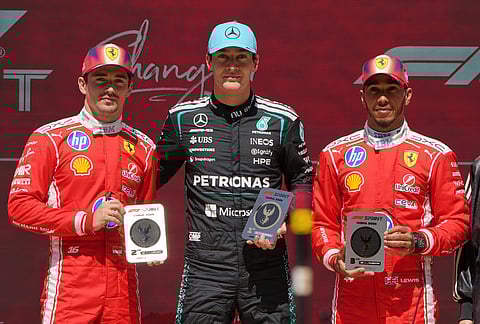 Winner Mercedes driver George Russell, center, of Britain poses with Ferrari driver Charles Leclerc, left, second place, of Monaco and Ferrari driver Lewis Hamilton, third place, of Britain after the Sprint Race of the Chinese Formula One Grand Prix at the Shanghai International Circuit, in Shanghai, China.