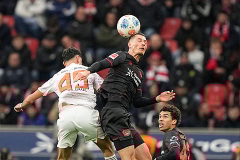 Leverkusen's Patrik Schick, centre, heads the ball ahead of Bayern's Aleksandar Pavlovic during a German Bundesliga soccer match between Bayer Leverkusen and Bayern Munich in Leverkusen, Germany.