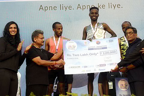 Indian badminton player PV Sindhu, left, during the award presentation ceremony for men's 42 km race winner Sadem Dese Husen of the 'Run for Nasha Mukt Bihar' Patna Marathon, in Patna.