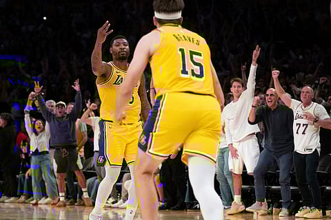 Los Angeles Lakers guard Marcus Smart, left, gestures after scoring a basket during the overtime of an NBA basketball game against the Denver Nuggets in Los Angeles.