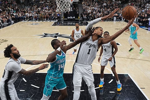 San Antonio Spurs forward Victor Wembanyama (1) grabs a rebound over Charlotte Hornets forward Moussa Diabate (14) during the second half of an NBA basketball game in San Antonio.