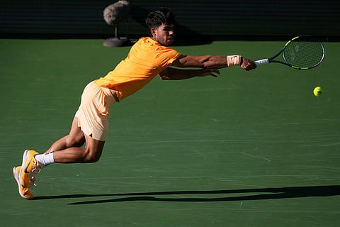 Carlos Alcaraz, of Spain, returns a shot against Daniil Medvedev, of Russia, during a semifinal match at the BNP Paribas Open tennis tournament in Indian Wells, Calif.