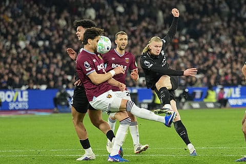 West Ham's Konstantinos Mavropanos, left, blocks a shot by Manchester City's Erling Haaland during the English Premier League soccer match between West Ham United and Manchester City in London, England.
