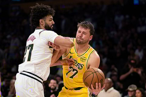 Los Angeles Lakers guard Luka Doncic, right, drives to the basket as Denver Nuggets guard Jamal Murray defends during the second half of an NBA basketball game in Los Angeles.