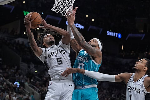 San Antonio Spurs guard Stephon Castle (5) grabs a rebound over rCharlotte Hornets forward Miles Bridges (0) during the second half of an NBA basketball game in San Antonio.