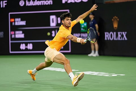 Carlos Alcaraz of Spain returns a shot to Cameron Norrie of Britain at the BNP Paribas Open tennis tournament in Indian Wells, Calif.