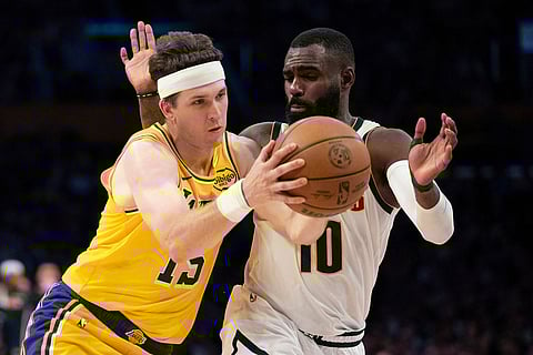 Los Angeles Lakers guard Austin Reaves, left, drives to the basket as Denver Nuggets guard Tim Hardaway Jr. defends during the second half of an NBA basketball game in Los Angeles.