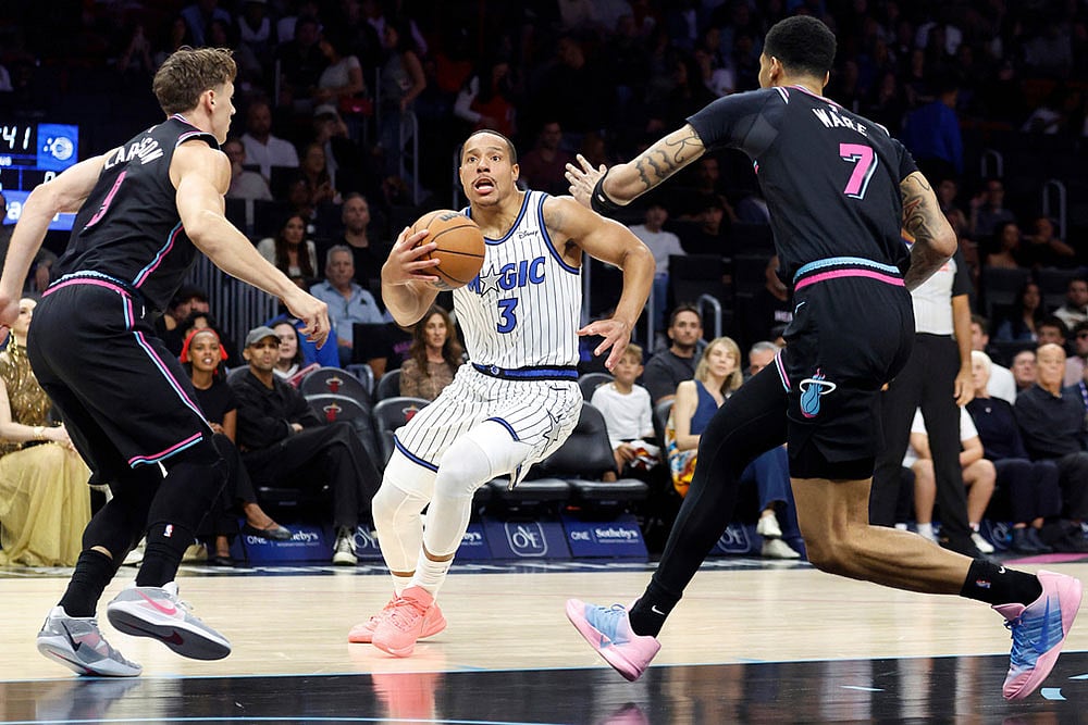 Miami Heat guard Pelle Larsson (9) and Miami Heat Kel'el Ware (7) defend Orlando Magic guard Desmond Bane (3) during the first half of an NBA basketball game in Miami. - | Photo: AP/Rhona Wise