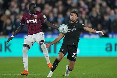 West Ham's El Hadji Malick Diouf, left, and Manchester City's Matheus Nunes compete for the ball during the English Premier League soccer match between West Ham United and Manchester City in London, England.