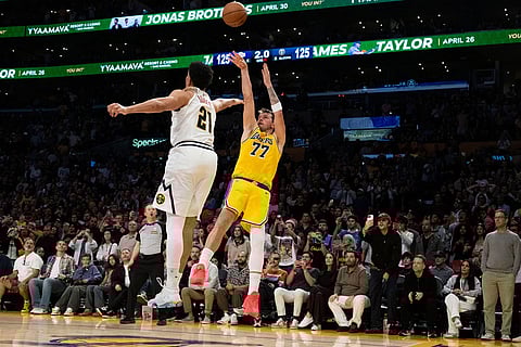 Los Angeles Lakers guard Luka Doncic, right, shoots as Denver Nuggets forward Spencer Jones, left, defends during the overtime of an NBA basketball game in Los Angeles.