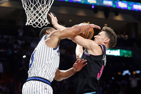 Orlando Magic guard Desmond Bane (3) fouls Miami Heat guard Pelle Larsson (9) during the second half of an NBA basketball game in Miami.