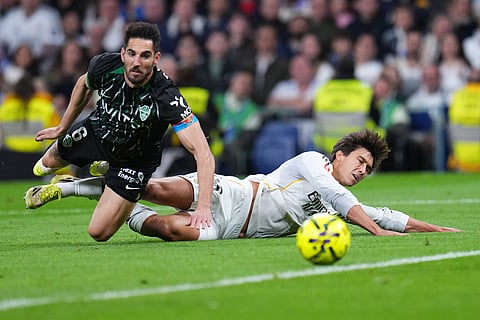 Real Madrid's Gonzalo Garcia, right, is challenged by Elche's Pedro Bigas during a Spanish La Liga soccer match between Real Madrid and Elche CF, in Madrid.