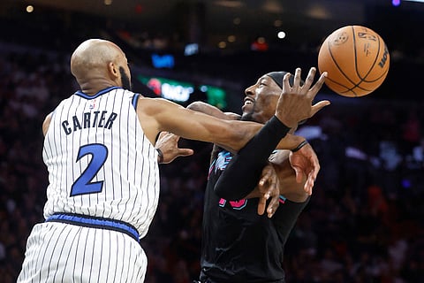 Orlando Magic guard Jevon Carter (2) fouls Miami Heat center Bam Adebayo (13) during the second half of an NBA basketball game in Miami.