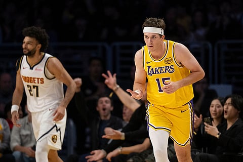 Los Angeles Lakers guard Austin Reaves, right, gestures after scoring a basket during the first half of an NBA basketball game against the Denver Nuggets in Los Angeles.