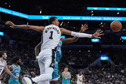 San Antonio Spurs forward Victor Wembanyama (1) and Charlotte Hornets forward Moussa Diabate (14) chase a rebound during the second half of an NBA basketball game in San Antonio.