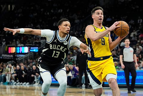 Indiana Pacers' T.J. McConnell (9) drives to the basket against Milwaukee Bucks' Ryan Rollins during the first half of an NBA basketball game, in Milwaukee.
