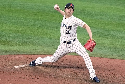 Japan's pitcher Atsuki Taneichi delivers a pitch during the eighth inning of a World Baseball Classic quarterfinal game against Venezuala in Miami. 