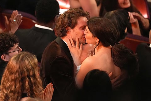Gunnar Eiriksson, left, kisses Inga Ibsdotter Lilleaas after "Sentimental Value" wins the award for best international film during the Oscars at the Dolby Theatre in Los Angeles. 