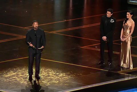 Michael B. Jordan accepts the award for actor in a leading role for "Sinners" during the Oscars at the Dolby Theatre in Los Angeles. Adrien Brody looks on from right.