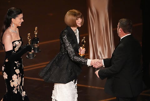 Anne Hathaway, far left, and Anna Wintour present the award for best makeup and hairstyling to Mike Hill for "Frankenstein" during the Oscars at the Dolby Theatre in Los Angeles. 