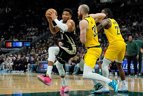 Milwaukee Bucks' Giannis Antetokounmpo (34) spins as he drives to the basket against Indiana Pacers' Jay Huff (32) during the second half of an NBA basketball game, in Milwaukee.
