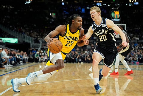 Indiana Pacers' Aaron Nesmith (23) drives to the basket against Milwaukee Bucks' AJ Green (20) during the first half of an NBA basketball game in Milwaukee.