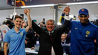  (AP Photo/Joan Monfort) : Joan Laporta, center, reacts as he poses with players Gavi, left, and Ronald Araujo after the voting for the election to be president of FC Barcelona in Barcelona, Spain, Sunday, March 15, 2026. 