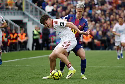 Sevilla's Manu Bueno, left, challenges for the ball with Barcelona's Dani Olmo during the Spanish La Liga soccer match between Barcelona and Sevilla in Barcelona, Spain.
