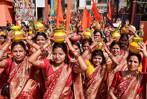 Women dressed in traditional attire hold 'kalash' during a procession as part of the 'Matri Sanskar Samagam' organised by the Vishwamangalya Sabha, in Varanasi.